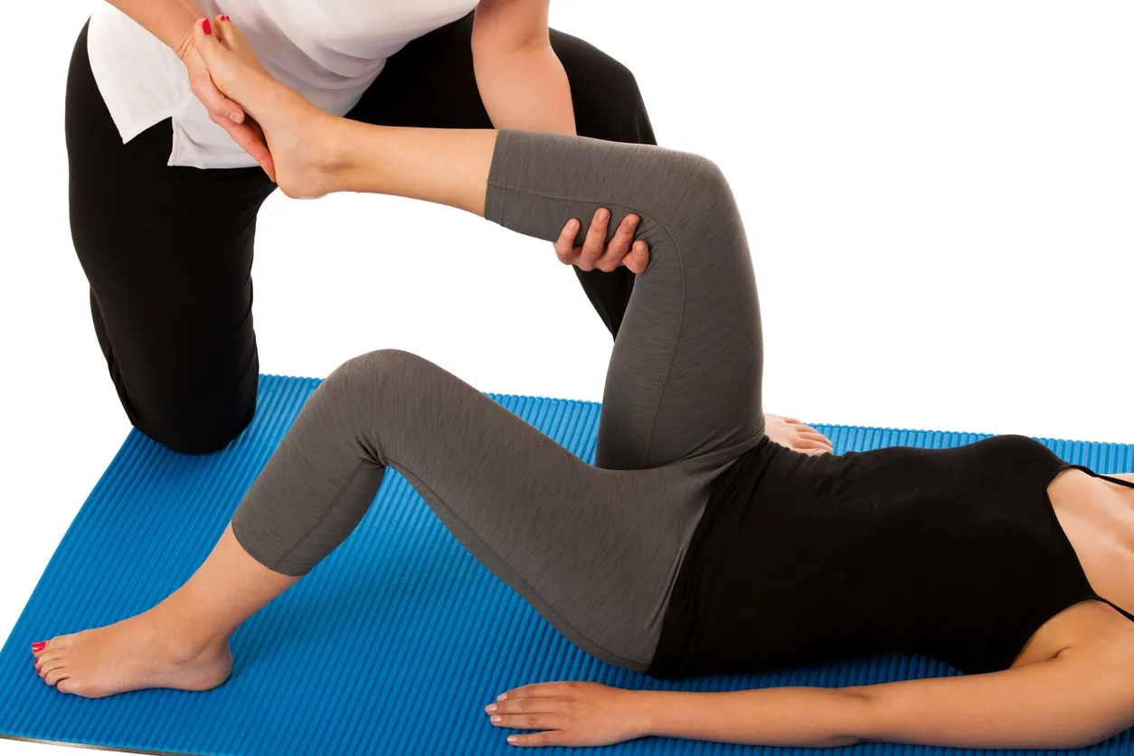 Physiotherapist assisting a patient with a leg stretch exercise